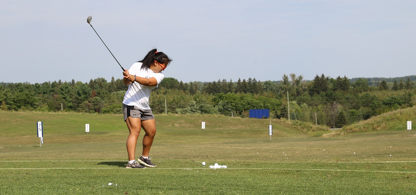 female golfer practices on driving range at bruce's mill conservation park