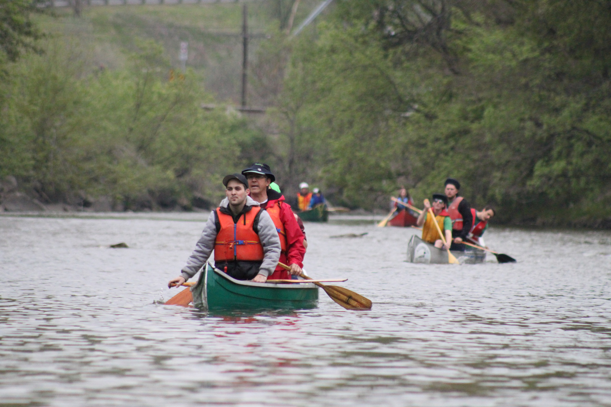 People in canoes paddling down a river