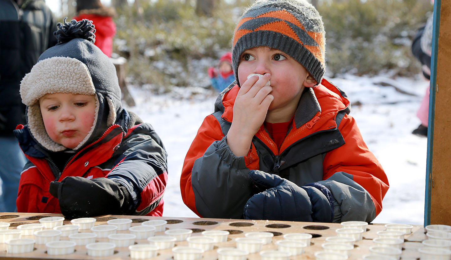 youngsters sample maple syrup at the Sugarbush Maple Syrup Festival