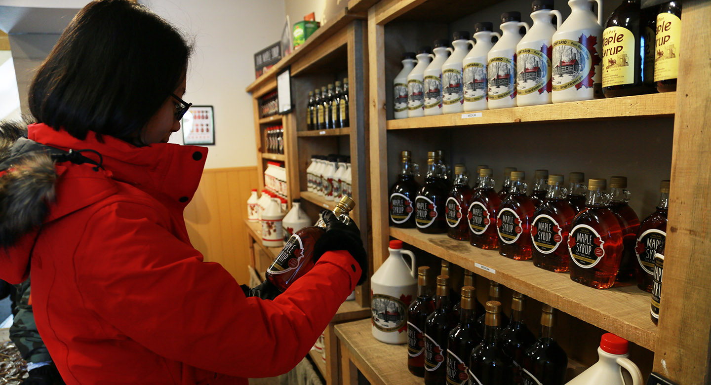 woman shopping for maple syrup at gift store