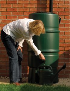 A person collect rainwater from the rain barrel