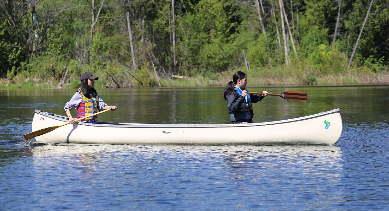 girls paddle canoe on Lake St George