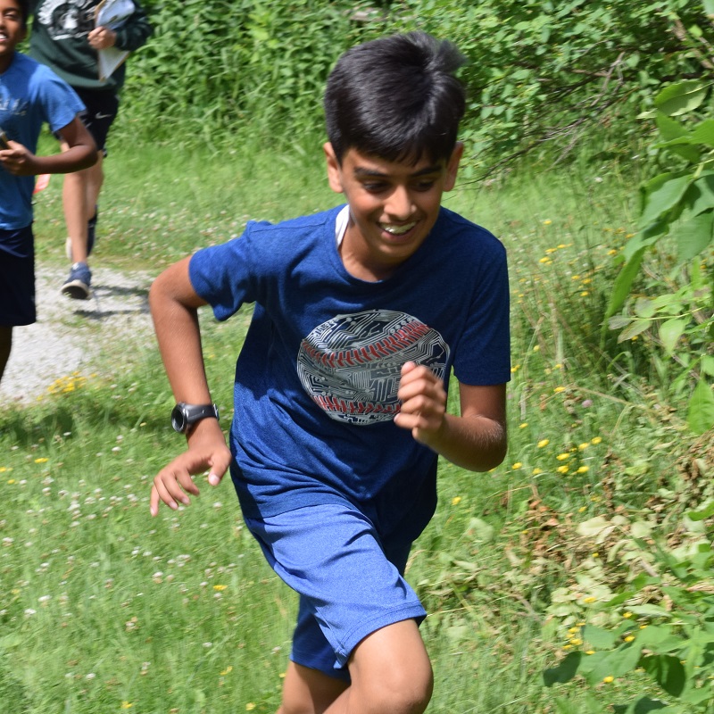 summer camper running through field at Albion Hills Field Centre