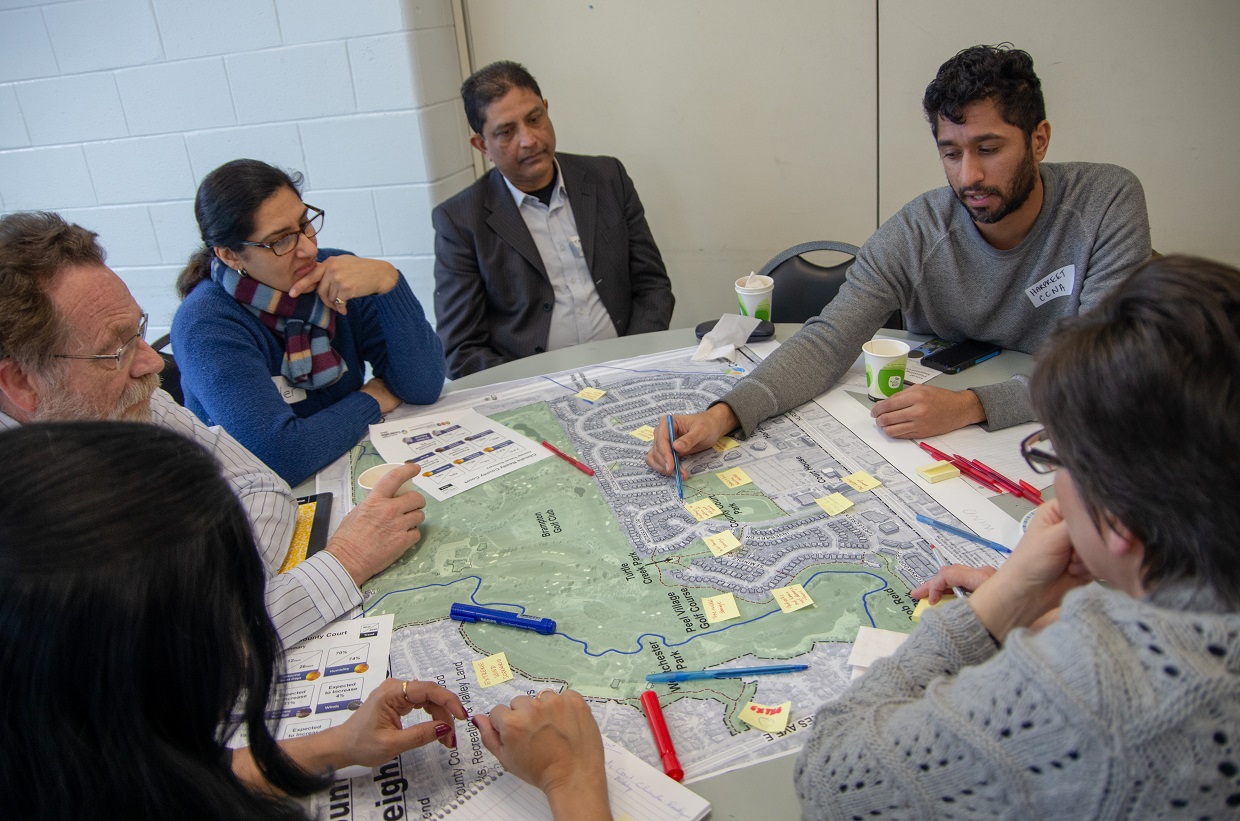 group of participants sitting around a large map of county court neighbourhood and making notes on the map