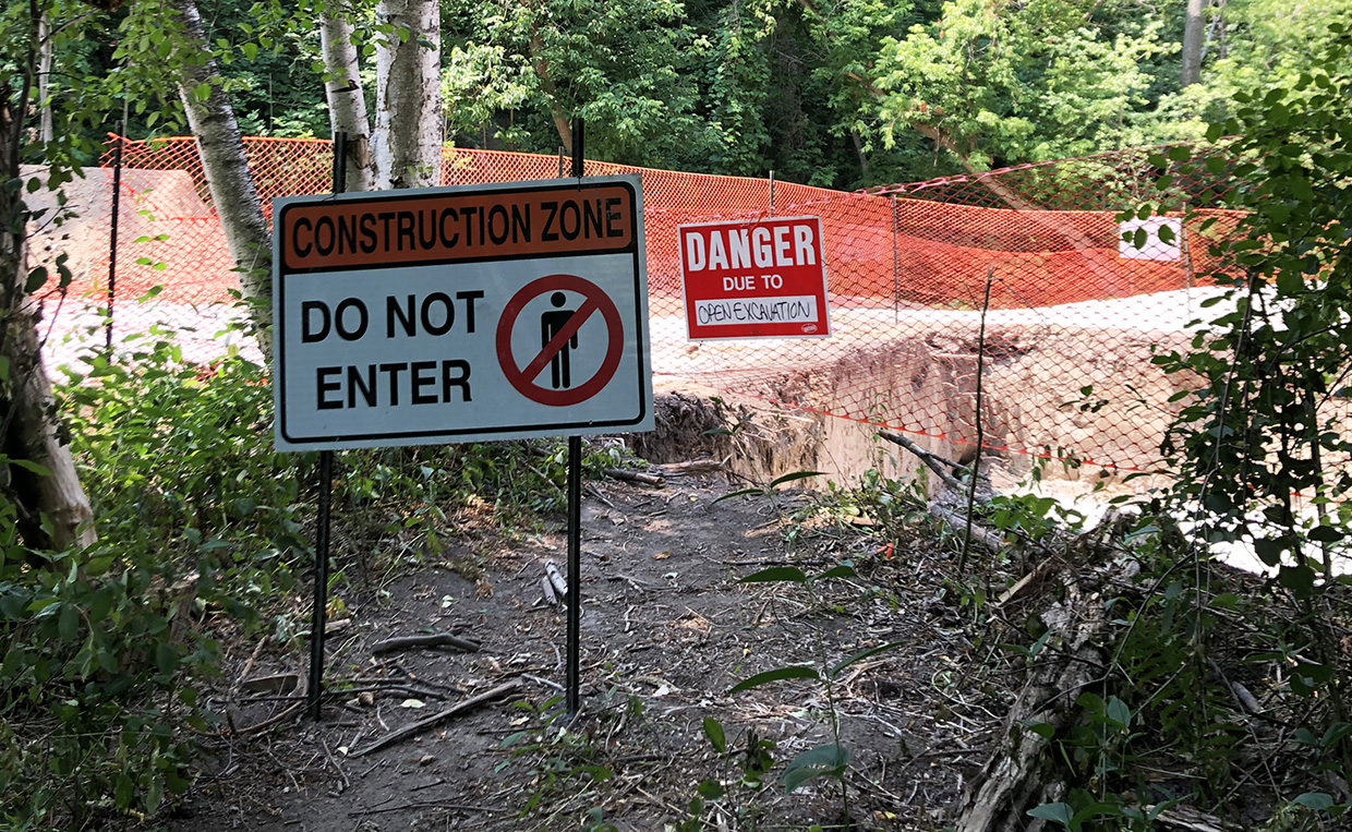 perimeter fencing and warning signage posted at East Don Trail active construction area